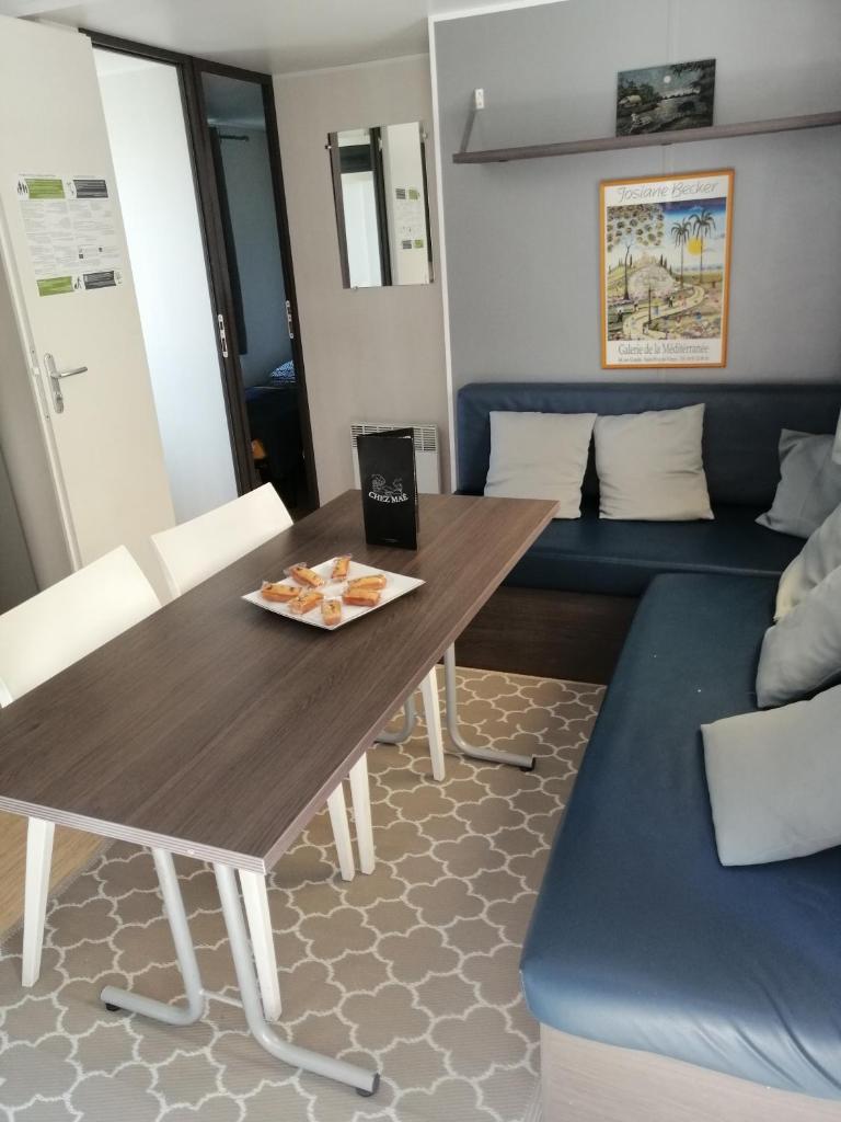 une salle à manger avec une table et un canapé dans l'établissement Mobil home chez Alain120, à La Roque-dʼAnthéron