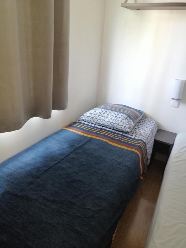 - un petit lit dans un coin de chambre dans l'établissement Mobil home chez Alain120, à La Roque-dʼAnthéron