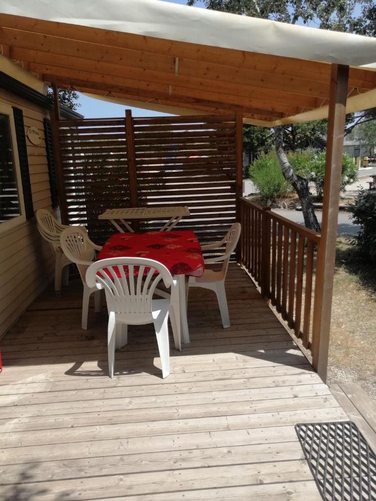 un patio avec une table et des chaises sur une terrasse dans l'établissement Mobil home chez Alain120, à La Roque-dʼAnthéron