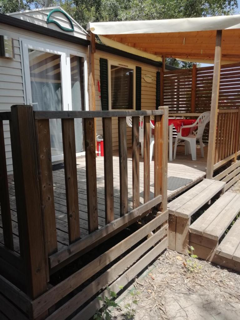 une terrasse en bois avec un porche et une maison dans l'établissement Mobil home chez Alain120, à La Roque-dʼAnthéron 7 autres photos