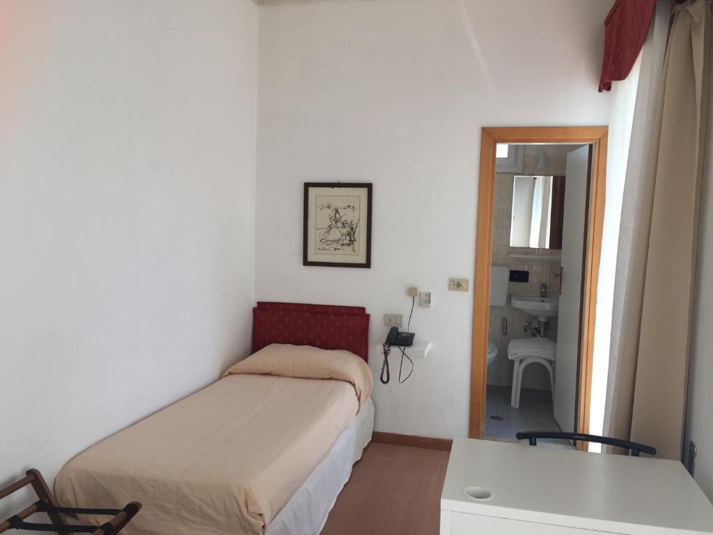 une petite chambre avec un lit et un miroir dans l'établissement Hotel Marlisa Pier, à Lido di Jesolo