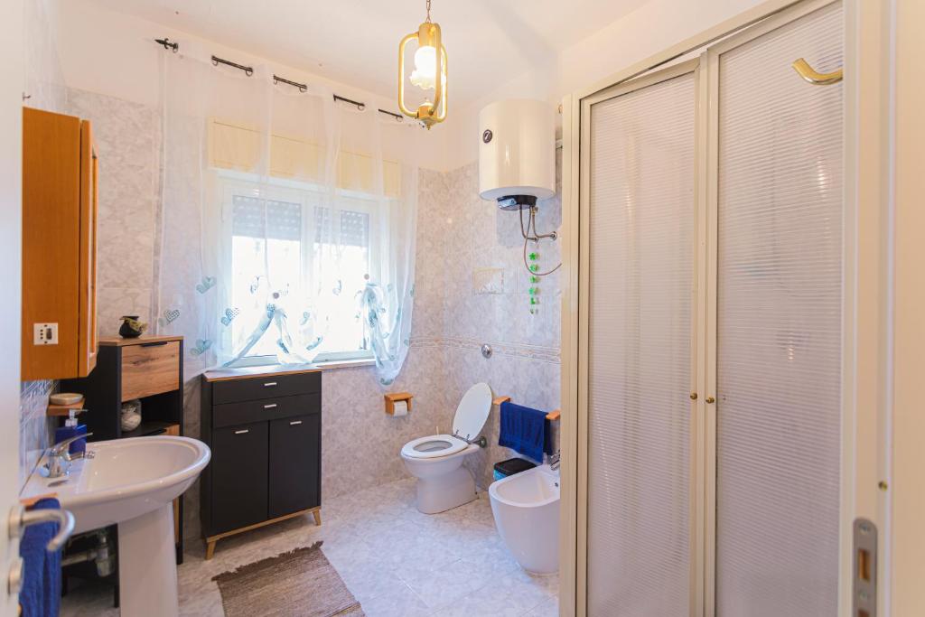 une salle de bain avec un lavabo, des toilettes et une douche dans l'établissement villa ulivo rovetto, à Mandra Capreria