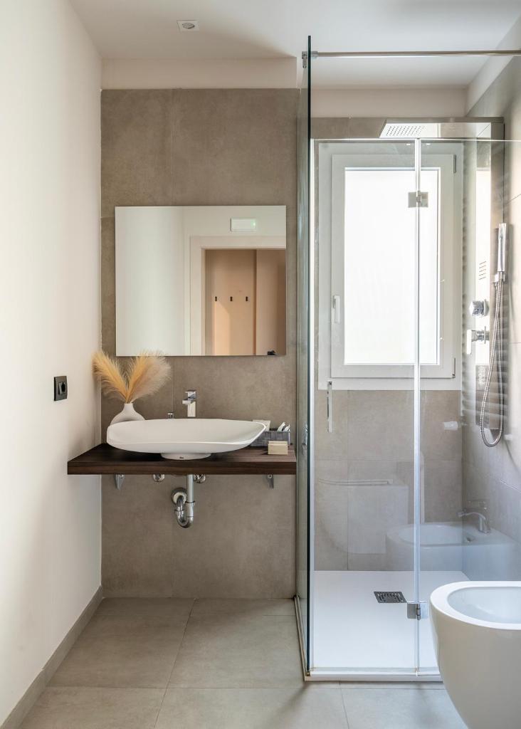 une salle de bain avec un lavabo et une douche en verre dans l'établissement Residence Goldoni6 Suite Apartment, à Rimini 106 autres photos