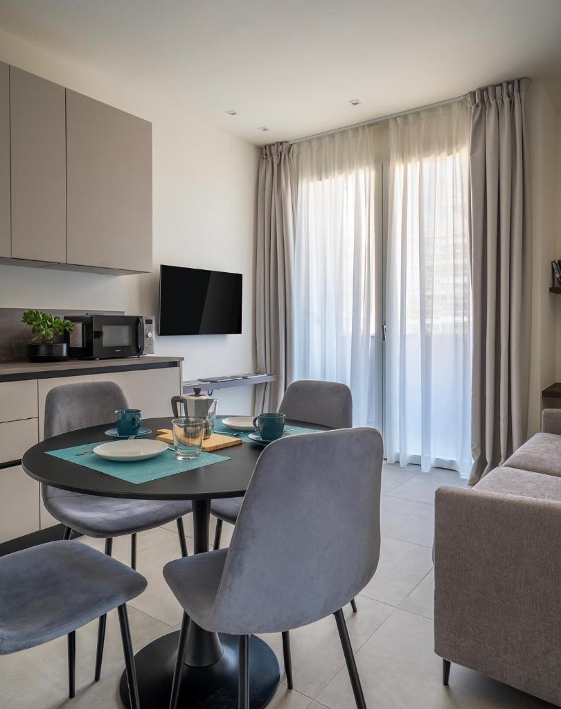 un salon avec une table et des chaises de salle à manger dans l'établissement Residence Goldoni6 Suite Apartment, à Rimini