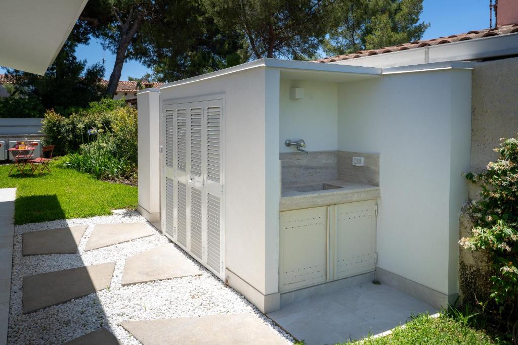 un hangar blanc avec un évier dans une cour dans l'établissement Villa Alice by Ortigiaapartments, à Syracuse