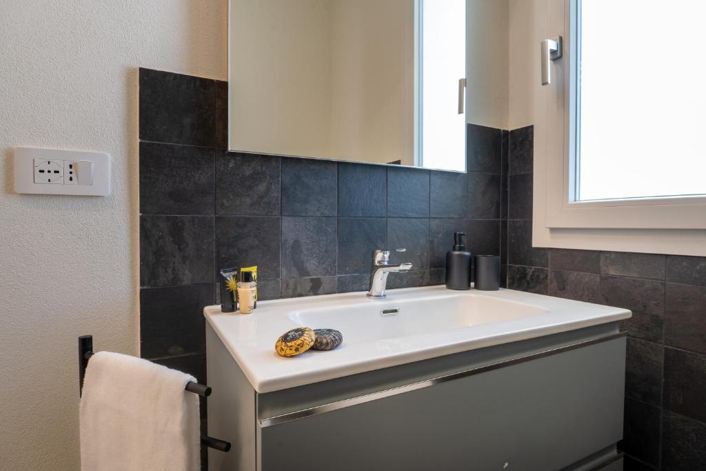une salle de bain avec un lavabo blanc et un miroir dans l'établissement Villa Alice by Ortigiaapartments, à Syracuse 38 autres photos