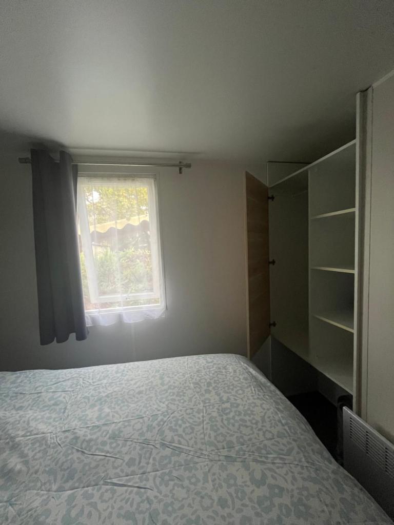 une chambre avec un lit et une fenêtre dans l'établissement Mobil home, à Sainte-Croix-de-Verdon