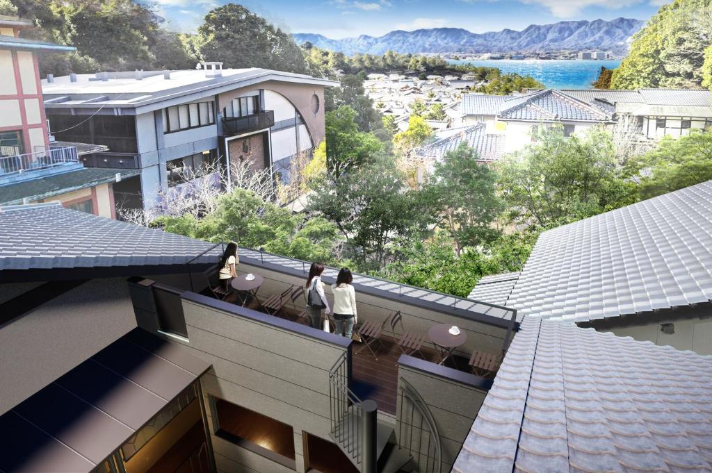 2 personnes debout sur le balcon d'un bâtiment dans l'établissement Kikunoya, à Miyajima