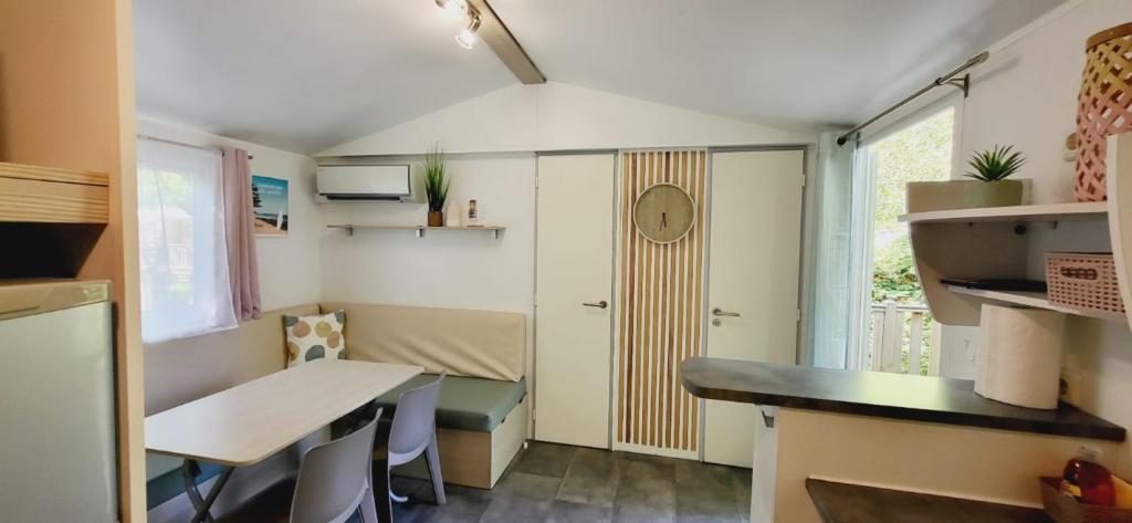 Cette petite chambre comprend un bureau et une table. dans l'établissement Mobil Home 4 6 pers climatisé Camping Eurolac, à Aureilhan