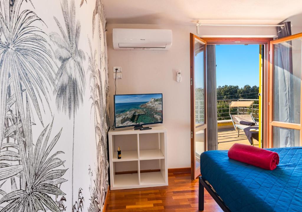 une chambre avec un lit bleu et un balcon dans l'établissement Marelì - magnifica villa con piscina, à Livourne 64 autres photos