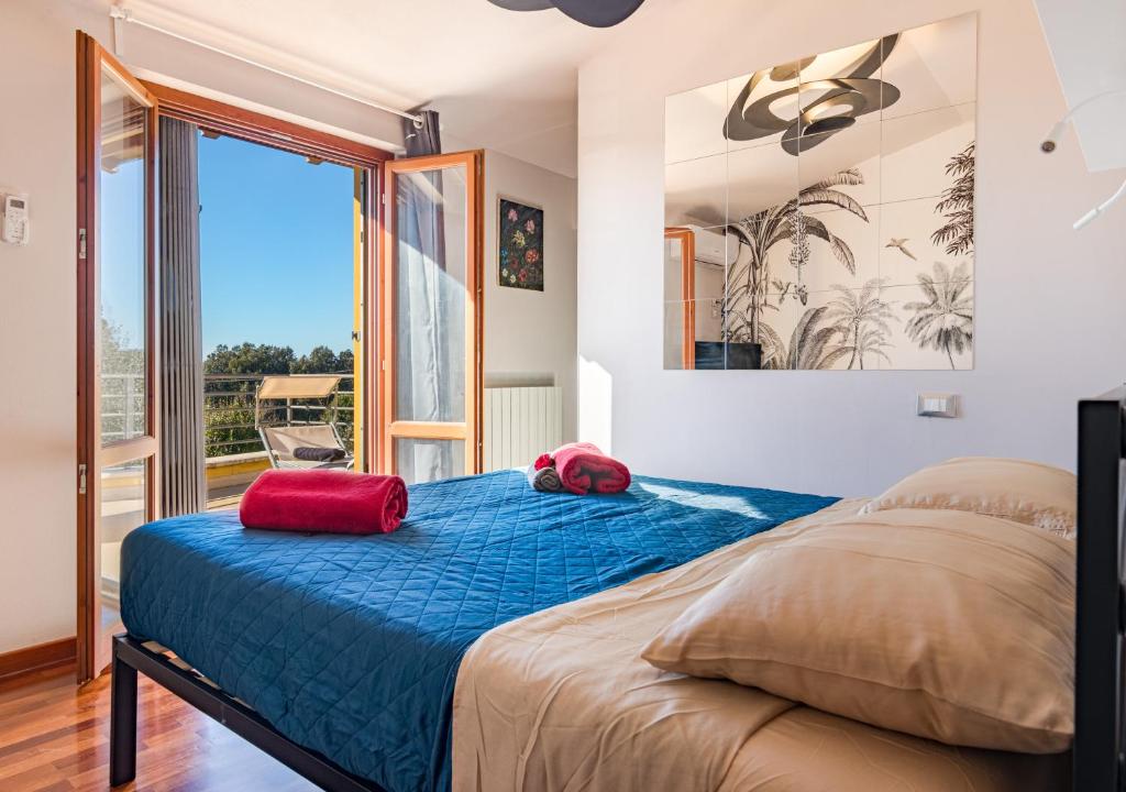 une chambre avec un lit avec deux oreillers rouges dessus dans l'établissement Marelì - magnifica villa con piscina, à Livourne