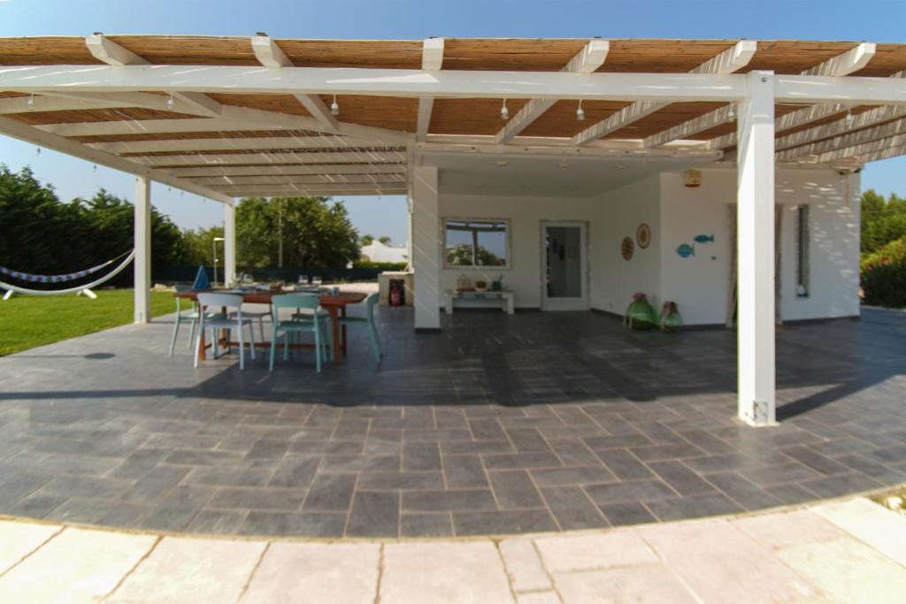 - un pavillon avec une table et des chaises sur la terrasse dans l'établissement Apulian Maison, à Ostuni