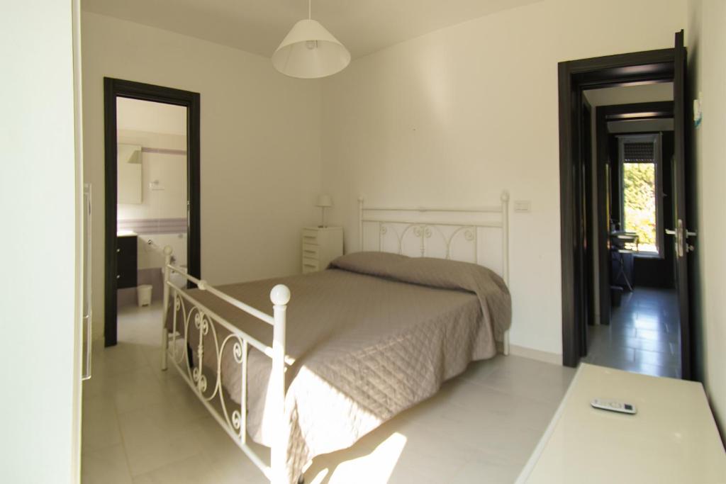 une chambre avec un lit dans une pièce blanche dans l'établissement Apulian Maison, à Ostuni