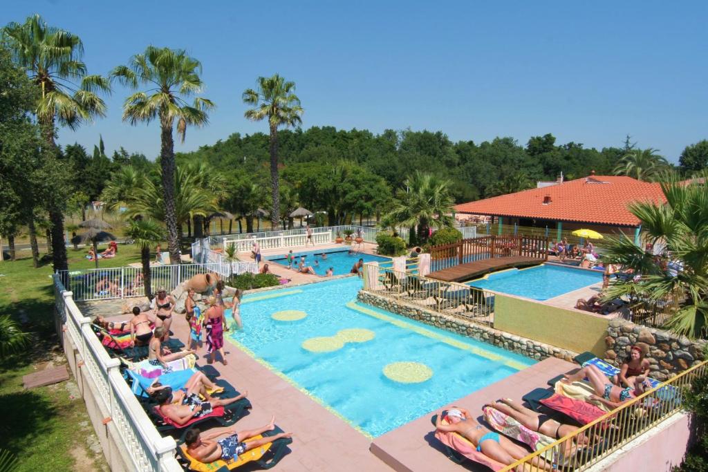- une piscine dans un complexe avec des chaises longues dans l'établissement Greenchalets Argeles Sur Mer Frankreich, à Argelès-sur-Mer