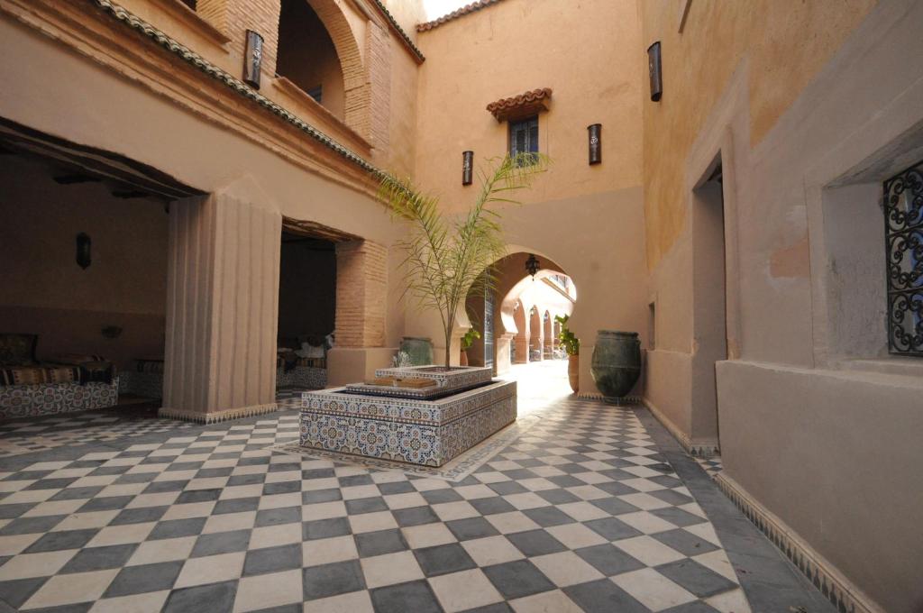 une cour avec une plante en pot au milieu d'un bâtiment dans l'établissement Riad Dar Dzahra, à Taroudant