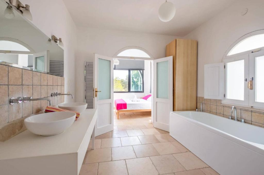 une grande salle de bain avec deux lavabos et une baignoire et un tubermott dans l'établissement Villa Azzurrato by Villa Plus, à Ceglie Messapica
