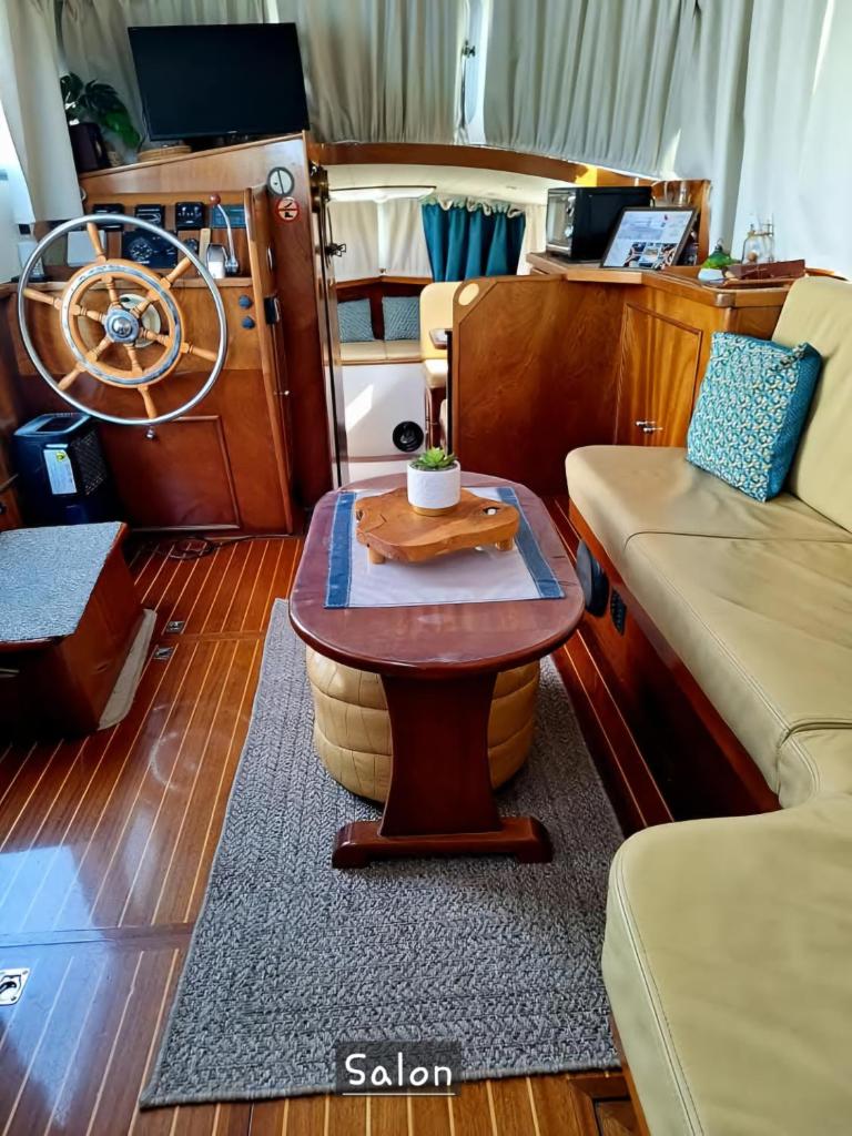 un salon avec une table sur un bateau dans l'établissement Bateau le Zimon - logement insolite, à Rouen 26 autres photos
