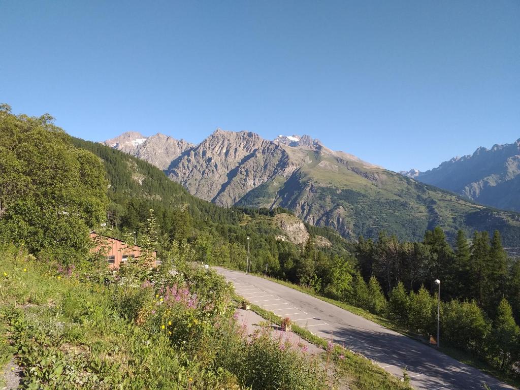 une route avec une montagne en arrière-plan dans l'établissement La Voile - Pendine 2 - Puy Saint Vincent - Hautes Alpes, à Puy-Saint-Vincent