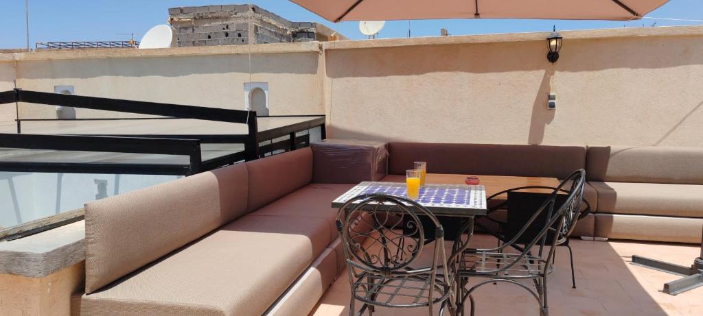 d'une petite table et de chaises sur un balcon avec un parasol dans l'établissement Riad Come & Va, à Marrakech