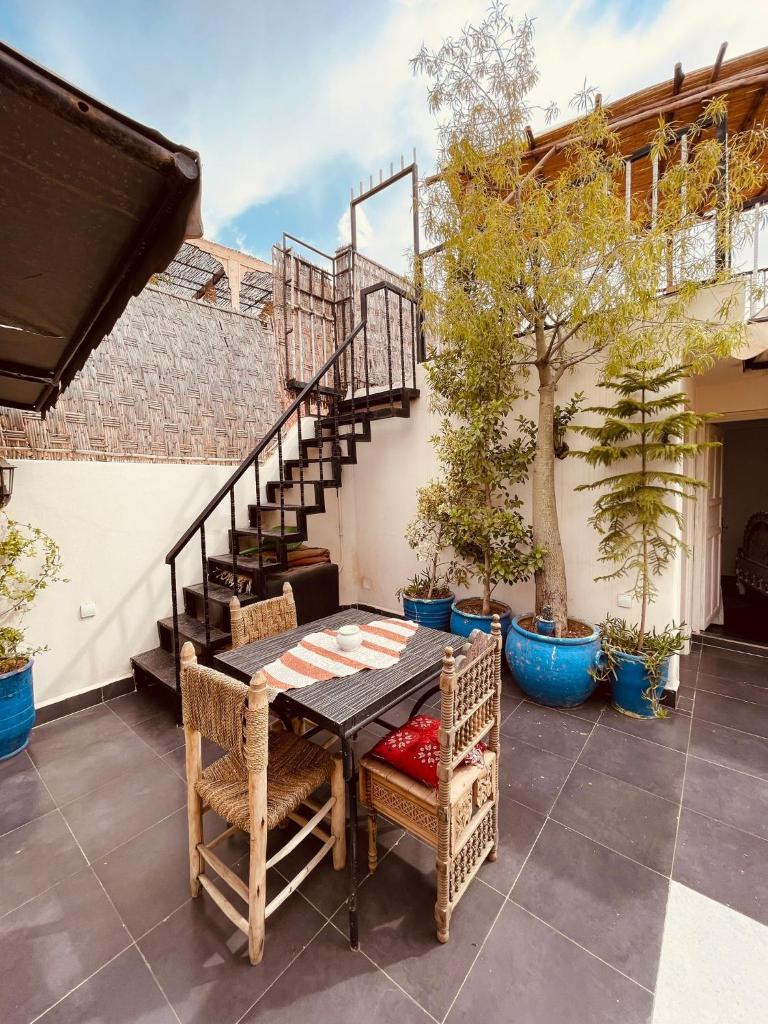 d'une terrasse avec une table, des chaises et des escaliers. dans l'établissement Diamant La Ville Rouge, à Marrakech