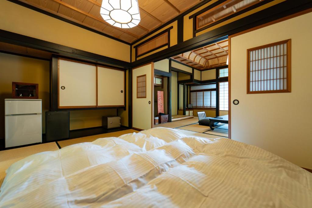 une chambre avec un grand lit blanc dans une pièce dans l'établissement Osawayama Onsen Osawakan, à Minami Uonuma 108 autres photos
