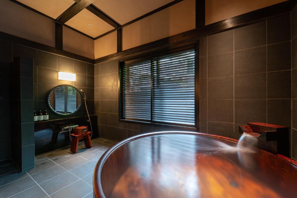 La salle de bains est pourvue d'une baignoire en verre et d'un miroir. dans l'établissement Osawayama Onsen Osawakan, à Minami Uonuma