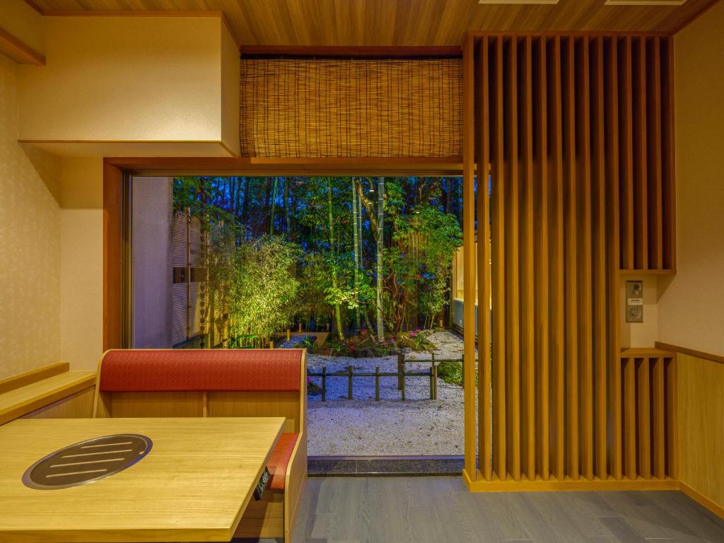 une pièce avec une table et une porte coulissante en verre dans l'établissement Mizunoto Reopening on April 1, 2025, à Hakone