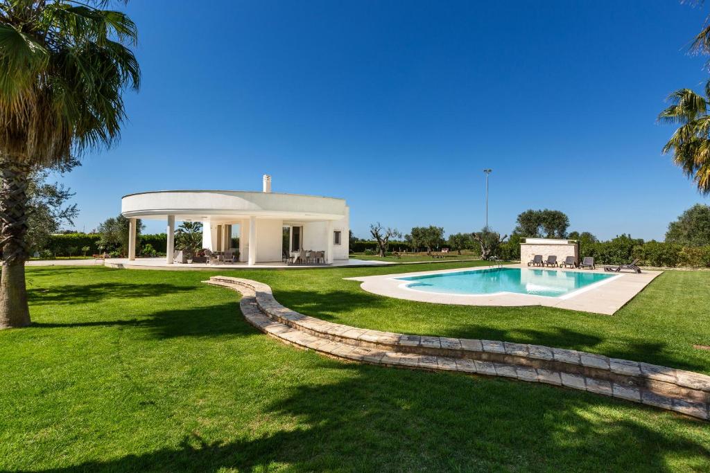 une maison avec une piscine dans une cour dans l'établissement Tenuta Bouganville by Perle di Puglia, à Francavilla Fontana