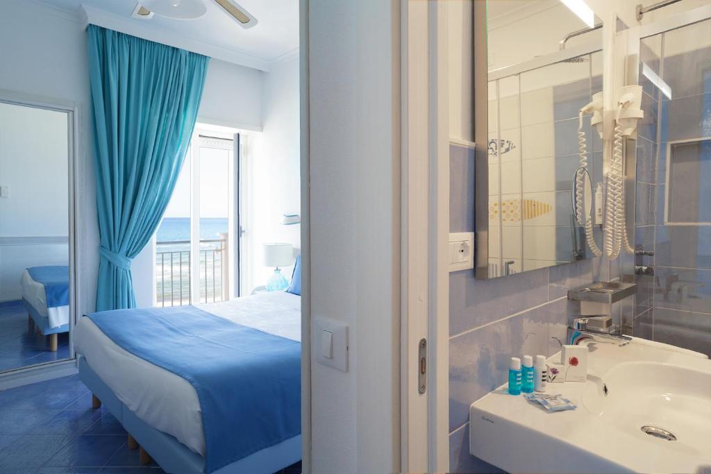 une chambre avec un lit et une salle de bain avec un lavabo dans l'établissement Hotel Aurora, à Sperlonga 264 autres photos