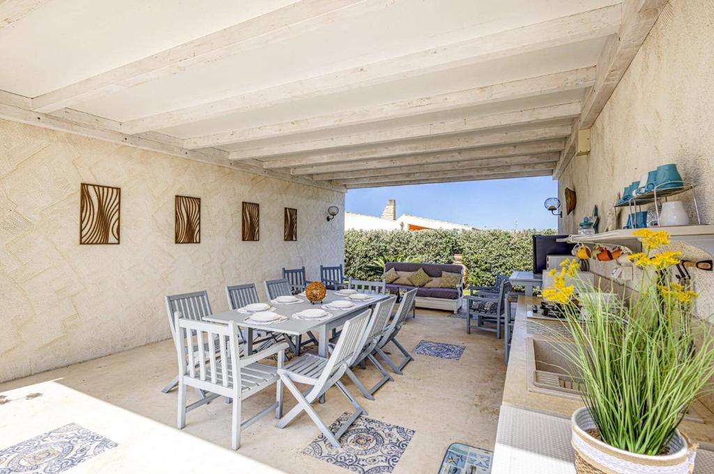 un patio avec une table, des chaises et un canapé dans l'établissement Villa Rosso Blu by Villa Plus, à Santa Maria Del Focallo 38 autres photos