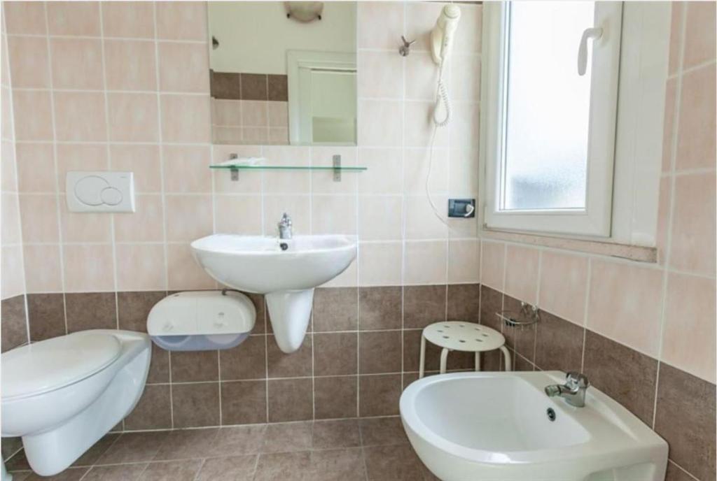 une salle de bain avec un lavabo et des toilettes dans l'établissement Hotel La Torre, à Cervia 31 autres photos