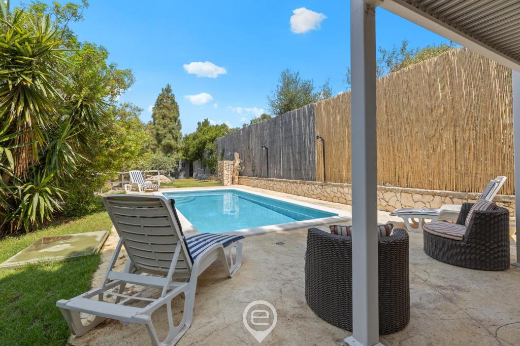 - une piscine avec 2 chaises longues à côté de la piscine dans l'établissement Villa Luce, à Torre delle Stelle