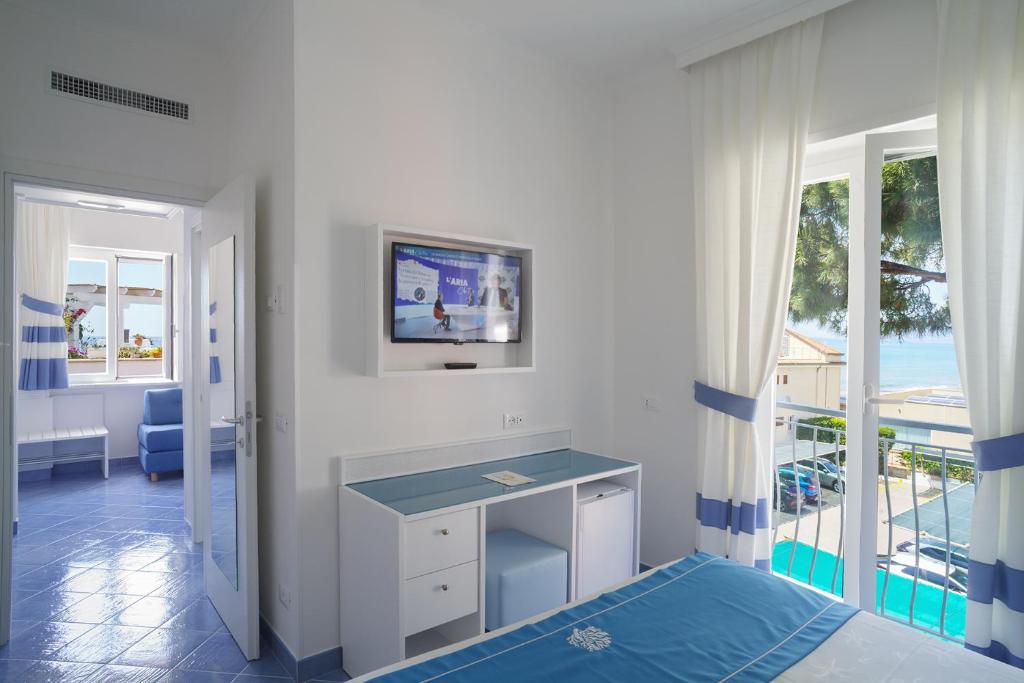 une chambre avec un bureau et une vue sur l'océan dans l'établissement Hotel Aurora, à Sperlonga