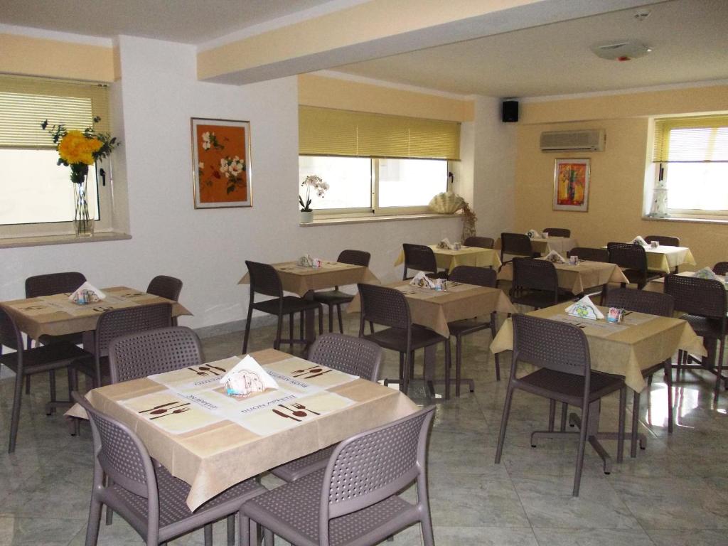 une salle à manger avec des tables et des chaises dans un restaurant dans l'établissement Hotel Solaria, à Rodi Garganico