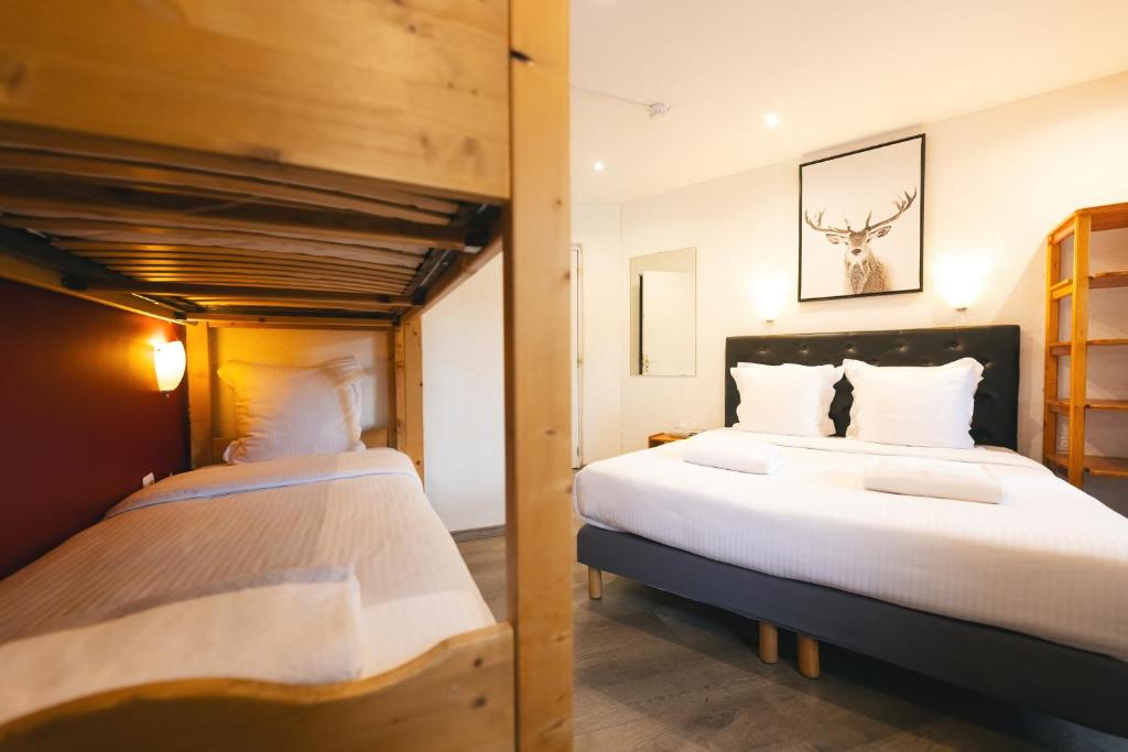 deux lits jumeaux dans une chambre avec dans l'établissement Le Loup Blanc, à Pra-Loup