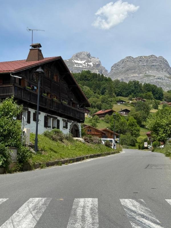 une maison sur le côté d'une route avec des montagnes dans l'établissement A Cordon entre Bois et Nature, à Cordon