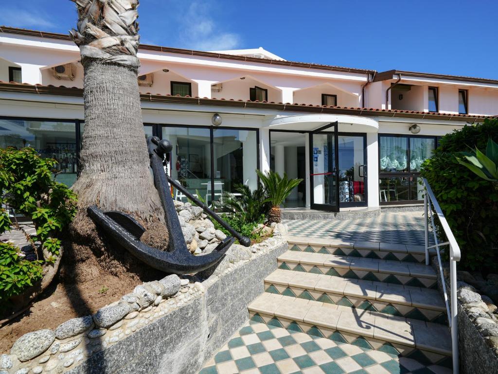 un palmier devant un bâtiment dans l'établissement Hotel MARINELLA - Private Free Parking - Grotticelle Beach 200 m, à Capo Vaticano