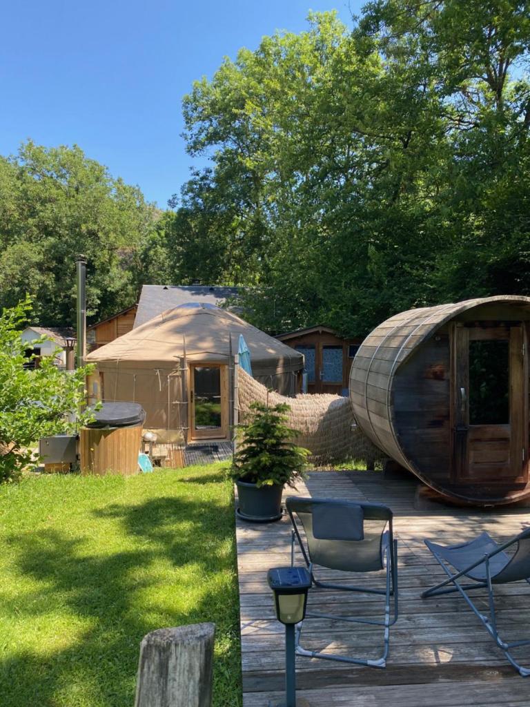une cour arrière avec une yourte et une terrasse avec des chaises dans l'établissement Yourte et son bain nordique, à Fréchet-Aure