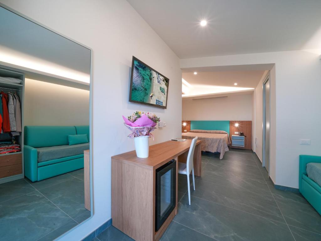 un salon avec une table avec des fleurs dessus dans l'établissement Hotel MARINELLA - Private Free Parking - Grotticelle Beach 200 m, à Capo Vaticano