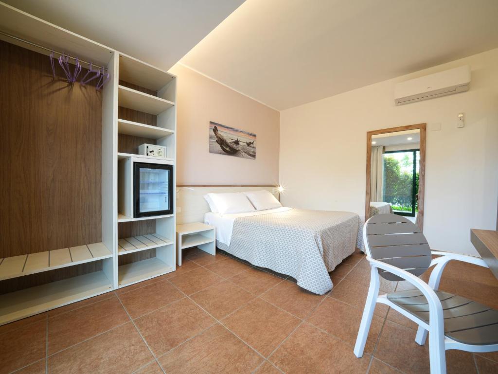 une chambre avec un lit et une télévision dans une pièce dans l'établissement Hotel MARINELLA - Private Free Parking - Grotticelle Beach 200 m, à Capo Vaticano