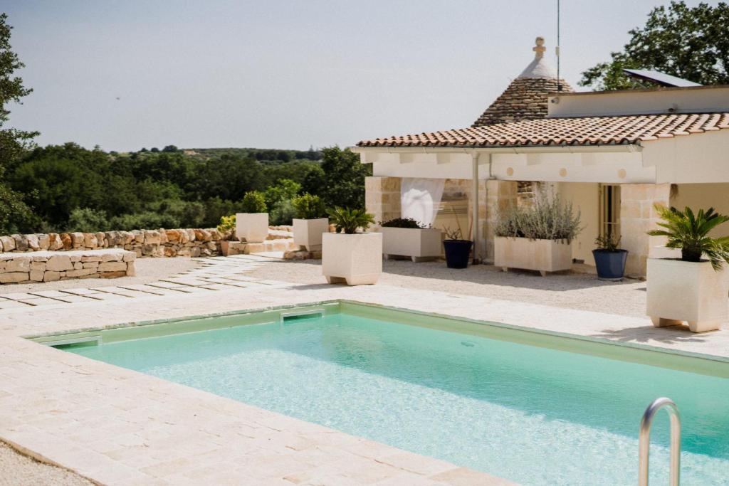 une piscine devant une maison dans l'établissement Trullo del Benessere, à Martina Franca