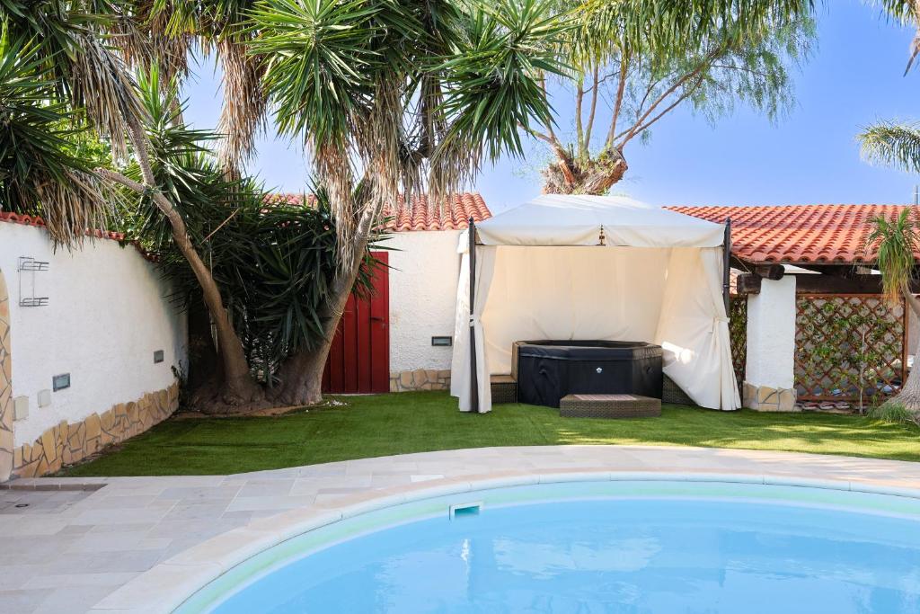 une maison avec une tente et une piscine dans l'établissement RIFLESSI D'AZZURRO - la vacanza dei tuoi sogni, à Castelvetrano