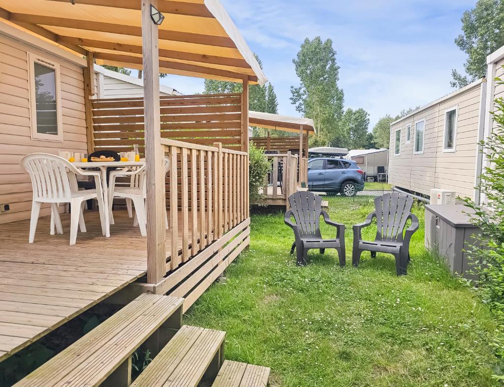 un patio avec une table et des chaises sur une terrasse dans l'établissement Camping Riva Bella, à Ouistreham