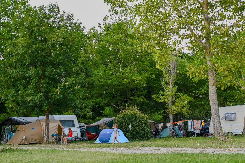 une personne debout devant un groupe de tentes dans l'établissement Camping Onlycamp Les Tuillères, à Vercheny