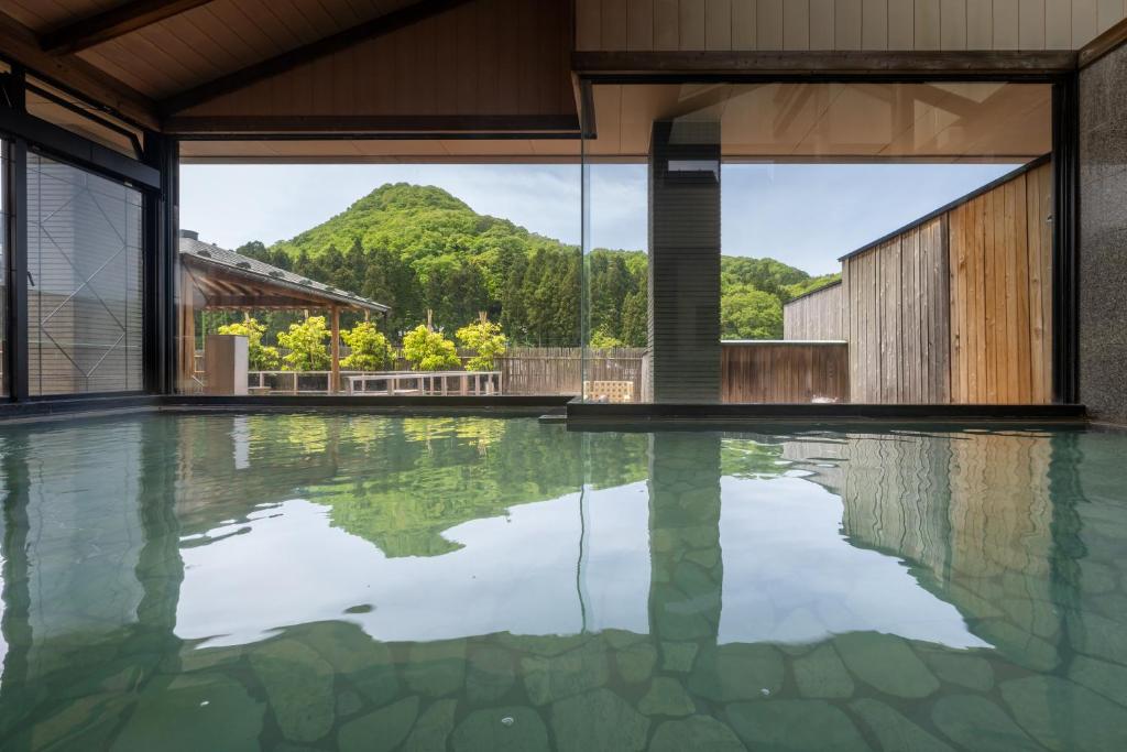 une piscine à débordement dans une maison avec une montagne en arrière-plan dans l'établissement Fujiya, à Niigata