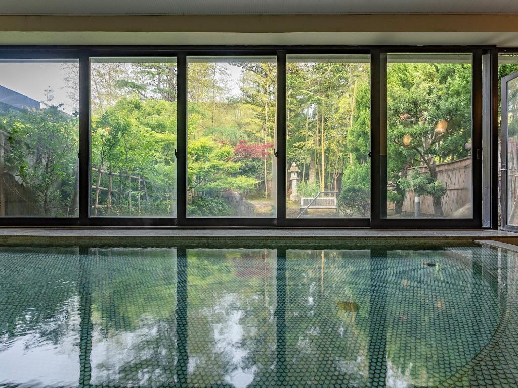 une maison avec une piscine et des fenêtres dans l'établissement Livemax Resort Yuhigaura Kitu Onsen, à Kyōtango