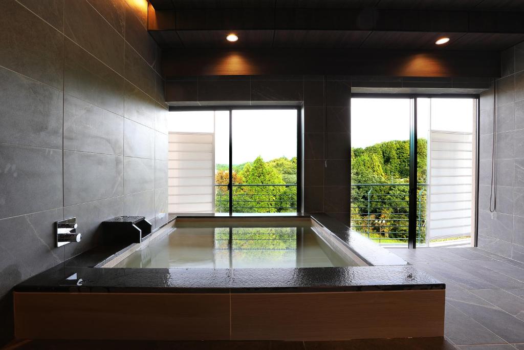 La salle de bains est pourvue d'une baignoire et d'une grande fenêtre. dans l'établissement Manten no Tsujinoya, à Komatsu