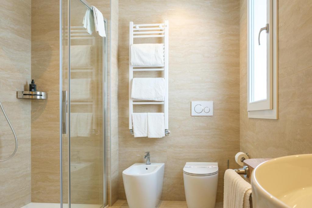 une salle de bain avec une douche, des toilettes et un lavabo dans l'établissement Hotel Montecarlo, à Lido di Jesolo