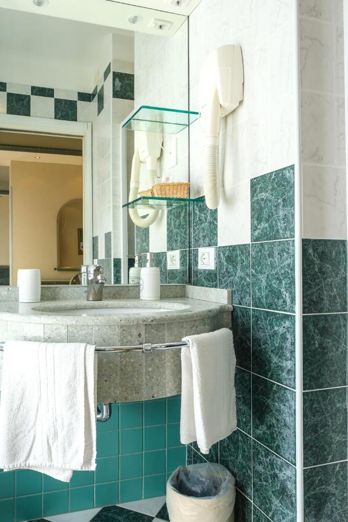 une salle de bain avec un lavabo et un miroir dans l'établissement Hotel Montecarlo, à Lido di Jesolo 19 autres photos