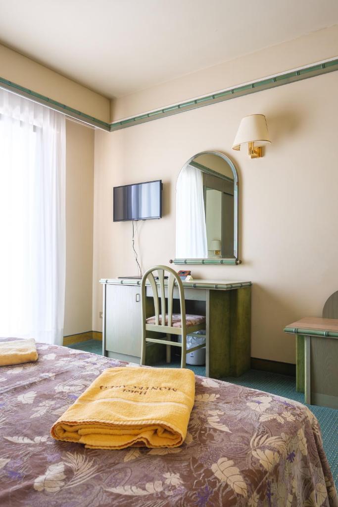 une chambre d'hôtel avec un lit et un miroir dans l'établissement Hotel Montecarlo, à Lido di Jesolo
